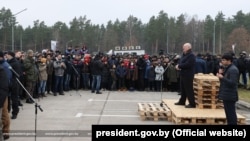 26 лістапада 2021 году. Аляксандар Лукашэнка выступае перад нелегальнымі мігрантамі ў лягістычным цэнтры ля памежнага пераходу Брузгі.