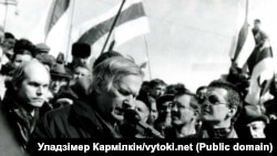 Васіль Быкаў выступае на мітынгу з нагоды Дня Волі ля Опэрнага тэатру ў Менску. Побач зь ім — Вінцук Вячорка (справа) і Лявон Баршчэўскі. 24 сакавіка 1996 году