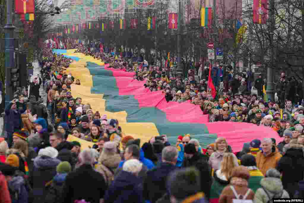 Людзі нясуць два вялізных сьцяга Літвы і Ўкраіны па праспэкце Гедыміна ў Вільні