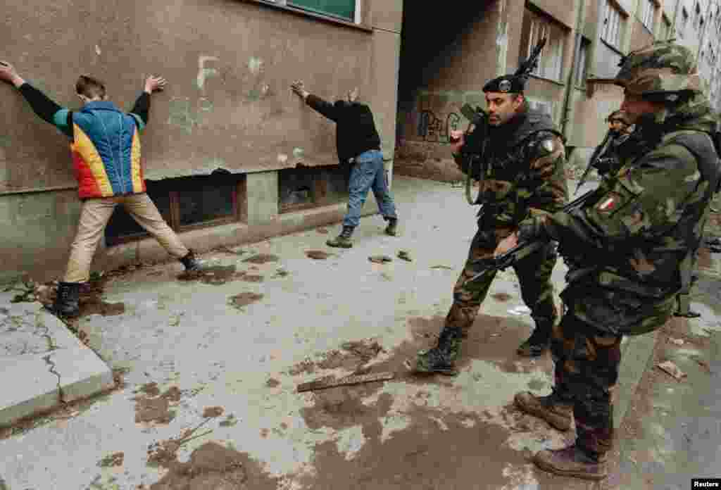 Італьянскія салдаты&nbsp;вартуюць падазраваных у падпалах у Сараеве ў сакавіку 1996. Дзясяткі тысяч вайскоўцаў NATO былі задзейнічаныя ў канфлікце ў Босьніі. З таго часу альянс прымяніў артыкул 5 супраць Афганістану пасьля тэрарыстычных нападаў 11 верасьня 2001 году і ўмяшаўся ў грамадзянскую вайну ў Лібіі.