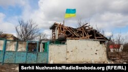 Украінскі сьцяг зноў узьняты ў вызваленым паселішчы. Лук'янаўка, 27 сакавіка 2022 г.