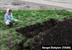 Дзячынка ў Марыюпалі каля магілы на пахаваньні яе сваякоў