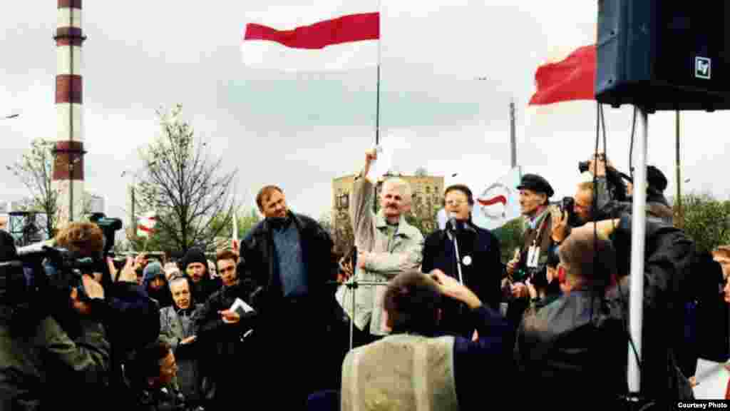 Алесь Бяляцкі на мітынгу паліць праект саюзнай дамовы з Расеяй. Побач зь ім Мікола Статкевіч, Вінцук Вячорка, Уладзімер Кармілкін. Менск, 1999