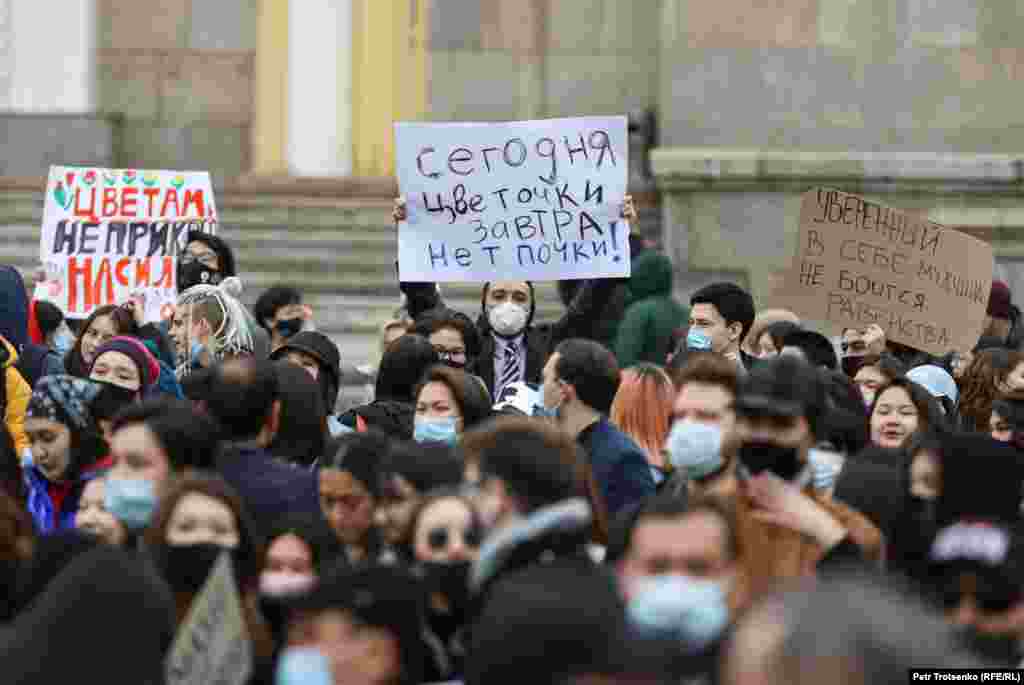 Участники марша за гендерное равенство поднимают плакаты.