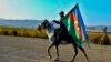 AZERBAIJAN -- An Azerbaijani soldier with a national flag rides a horse in Ganca, Azerbaijan's second largest city, near the border with Armenia, November 10, 2020