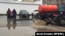 Жол-пайдалану кәсіпорнының қызметкерлері Батыс Қазақстан облысы әкімдігі маңындағы суды арнайы көлікпен сорып шығарып жатыр. Орал, 13 қараша 2015 жыл.