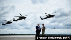 US -- US President Donald Trump (L) watches an air assault exercise with Army Major General Walter Piatt at Fort Drum, New York, on August 13, 2018. Trump spoke at a signing ceremony for the “John S. McCain National Defense Authorization Act for Fiscal Ye